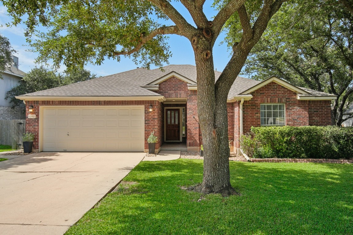 1207 Cedar Brook Drive Cedar Park, TX 78613 - Photo 1 of 1 a front view of a house with a garden and tree