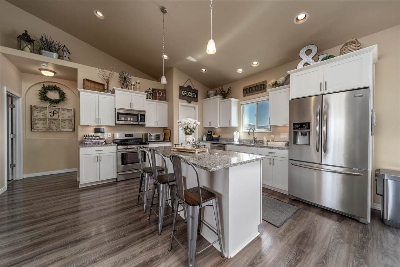 1554 17 Road Loma, CO 81524 - Photo 6 of 16 a kitchen with stainless steel appliances a refrigerator a stove a sink and white cabinets with wooden floor