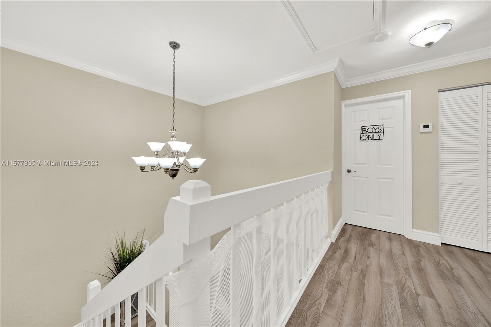 13339 Southwest 112th Terrace, Unit 504 Miami, FL 33186 - Photo 11 of 26 a view of a chandelier in a room with wooden floor