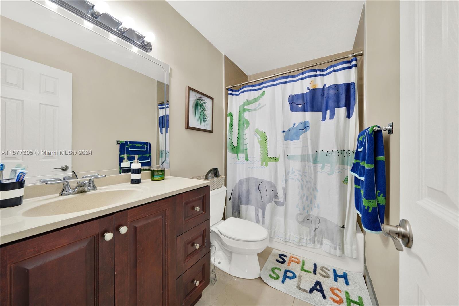 13339 Southwest 112th Terrace, Unit 504 Miami, FL 33186 - Photo 18 of 26 a spacious bathroom with a double vanity sink toilet and shower