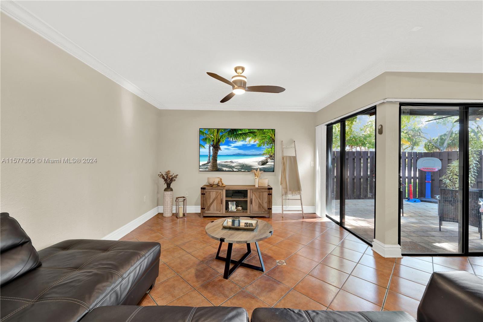 13339 Southwest 112th Terrace, Unit 504 Miami, FL 33186 - Photo 2 of 26 a living room with furniture a window and a flat screen tv