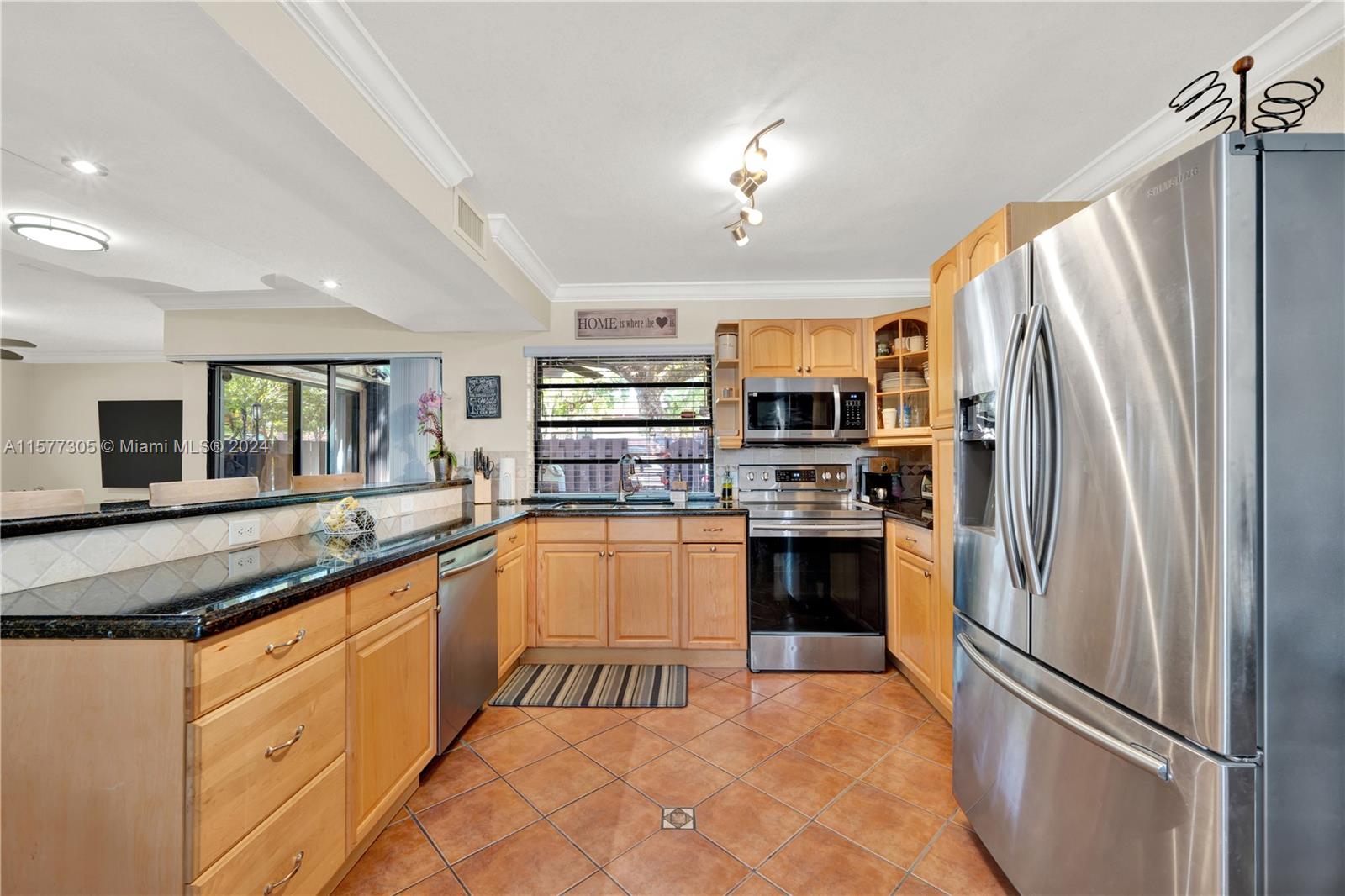 13339 Southwest 112th Terrace, Unit 504 Miami, FL 33186 - Photo 7 of 26 a kitchen with stainless steel appliances granite countertop a refrigerator and a stove top oven