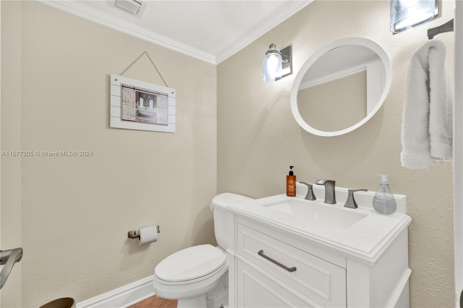 13339 Southwest 112th Terrace, Unit 504 Miami, FL 33186 - Photo 10 of 26 a bathroom with a toilet a sink and mirror
