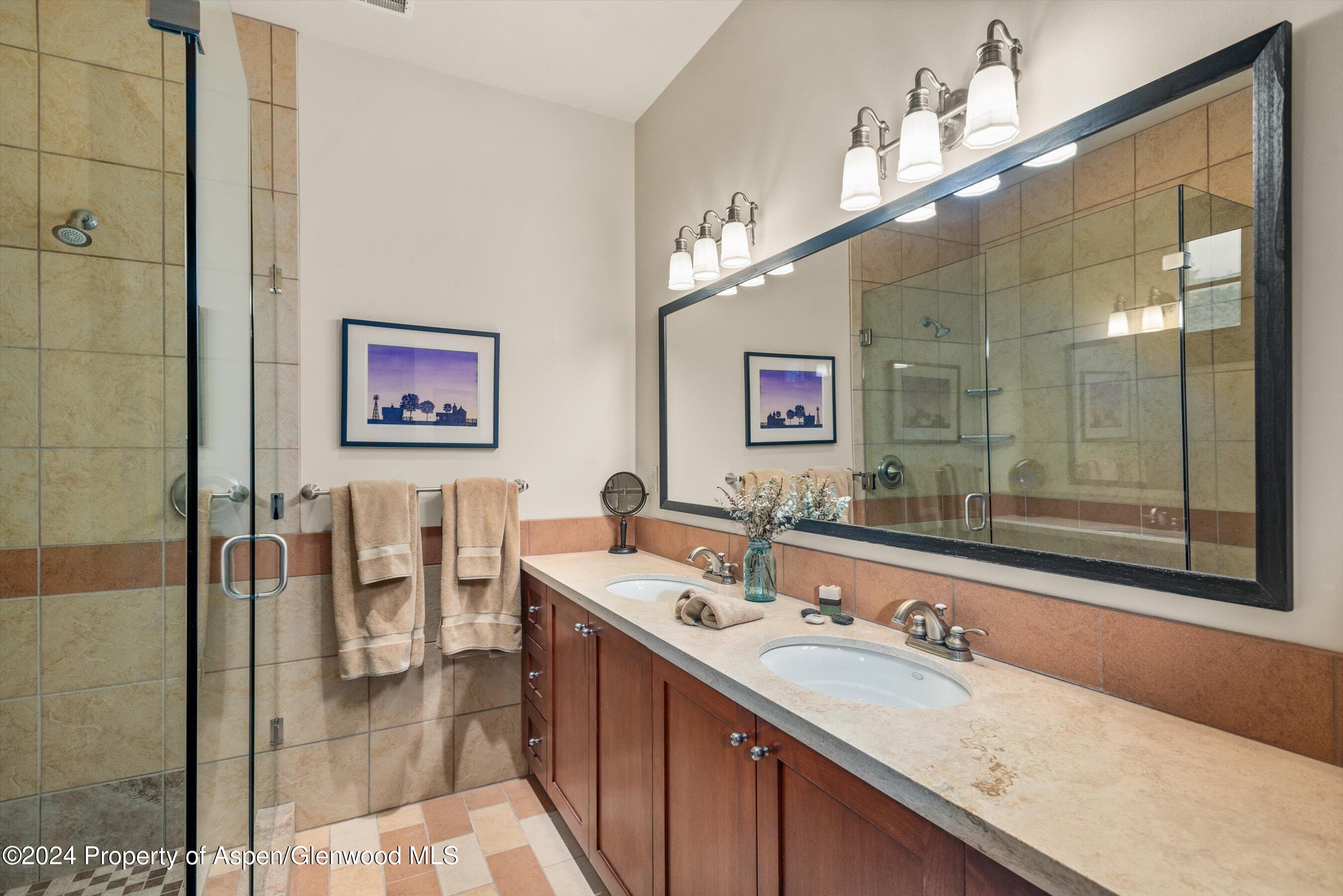 342 Sopris Circle Basalt, CO 81621 - Photo 29 of 34 a bathroom with a granite countertop double vanity sink a mirror and a shower