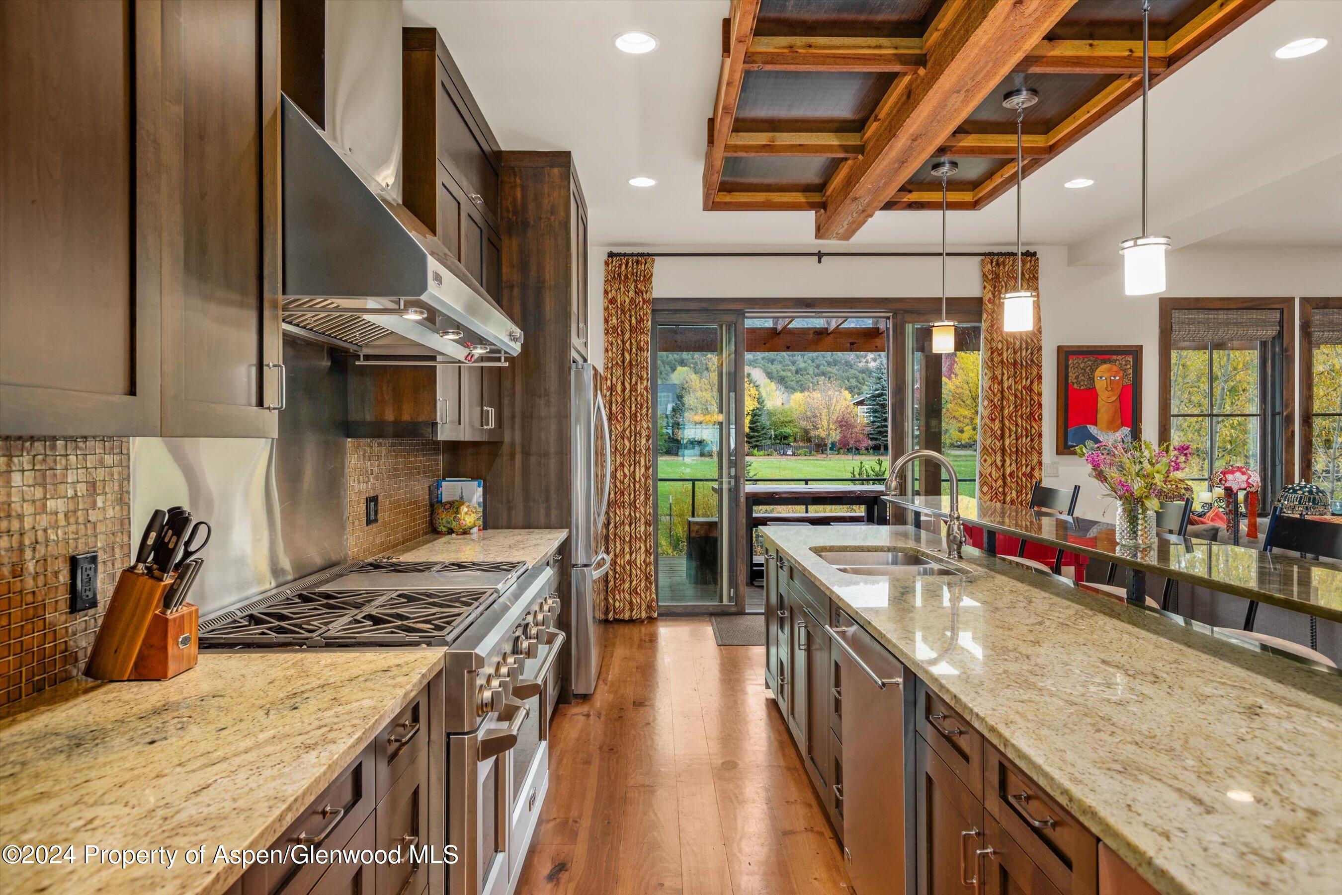 342 Sopris Circle Basalt, CO 81621 - Photo 4 of 34 a kitchen with stainless steel appliances granite countertop a lot of counter space and wooden floors