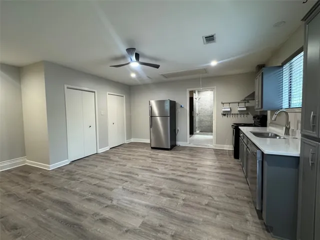 a view of a kitchen with a sink and a refrigerator