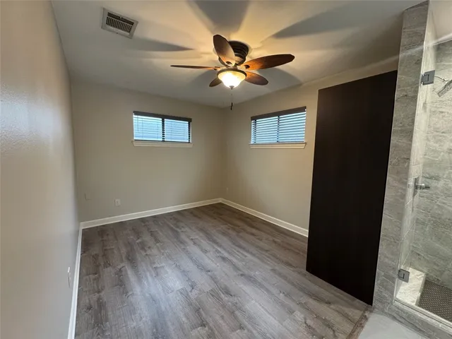 a view of an empty room with wooden floor