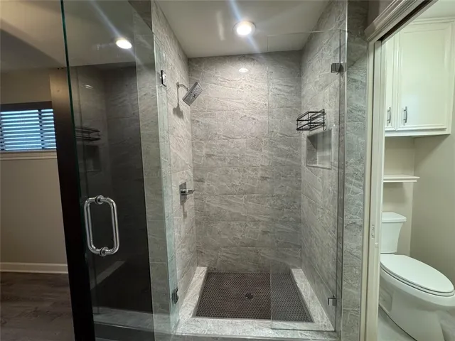 a bathroom with a shower a toilet and a sink