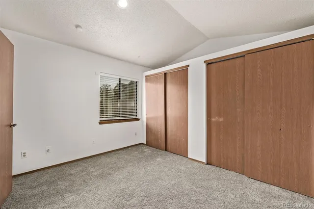an empty room with windows and closet
