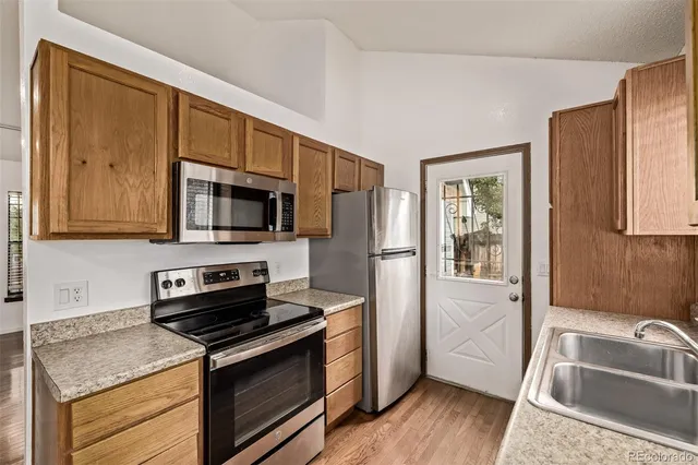 a kitchen with stainless steel appliances granite countertop a sink stove and microwave