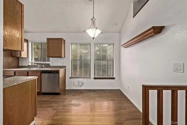 a view of a kitchen with a sink dishwasher a refrigerator and window
