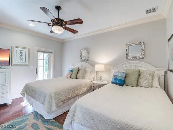 a bedroom with two separate beds and ceiling fan