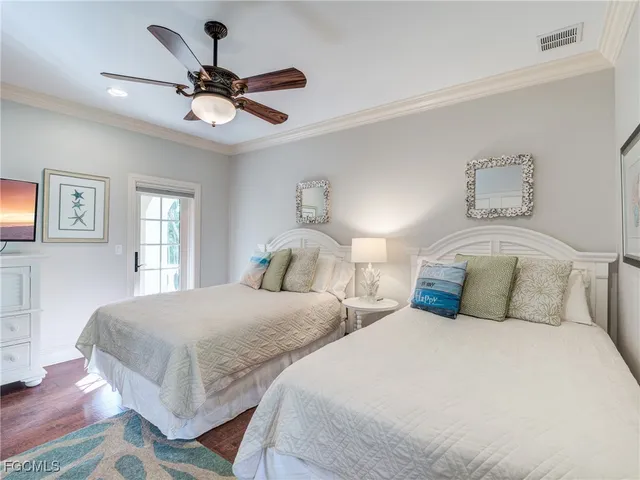 a bedroom with two separate beds and ceiling fan