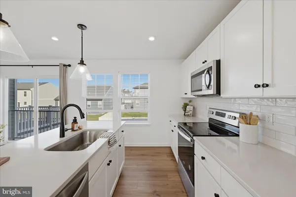 a kitchen with a sink a stove and cabinets