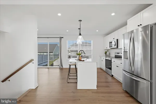 a kitchen with stainless steel appliances granite countertop a refrigerator a stove top oven a sink dishwasher and a refrigerator