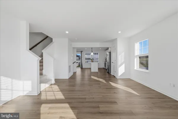 a view of empty room with wooden floor and windows
