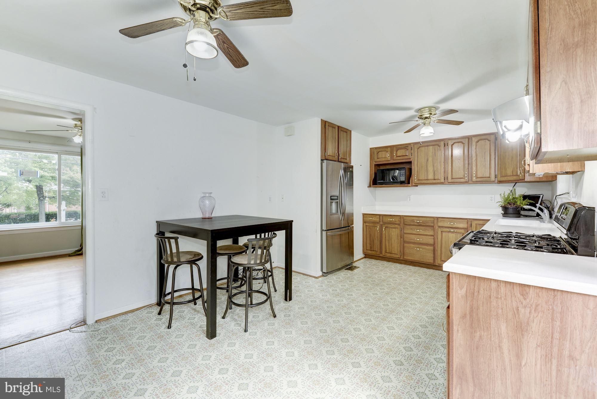 12510 Goodhill Road Silver Spring, MD 20906 - Photo 11 of 28 a kitchen with stainless steel appliances a table and chairs in it