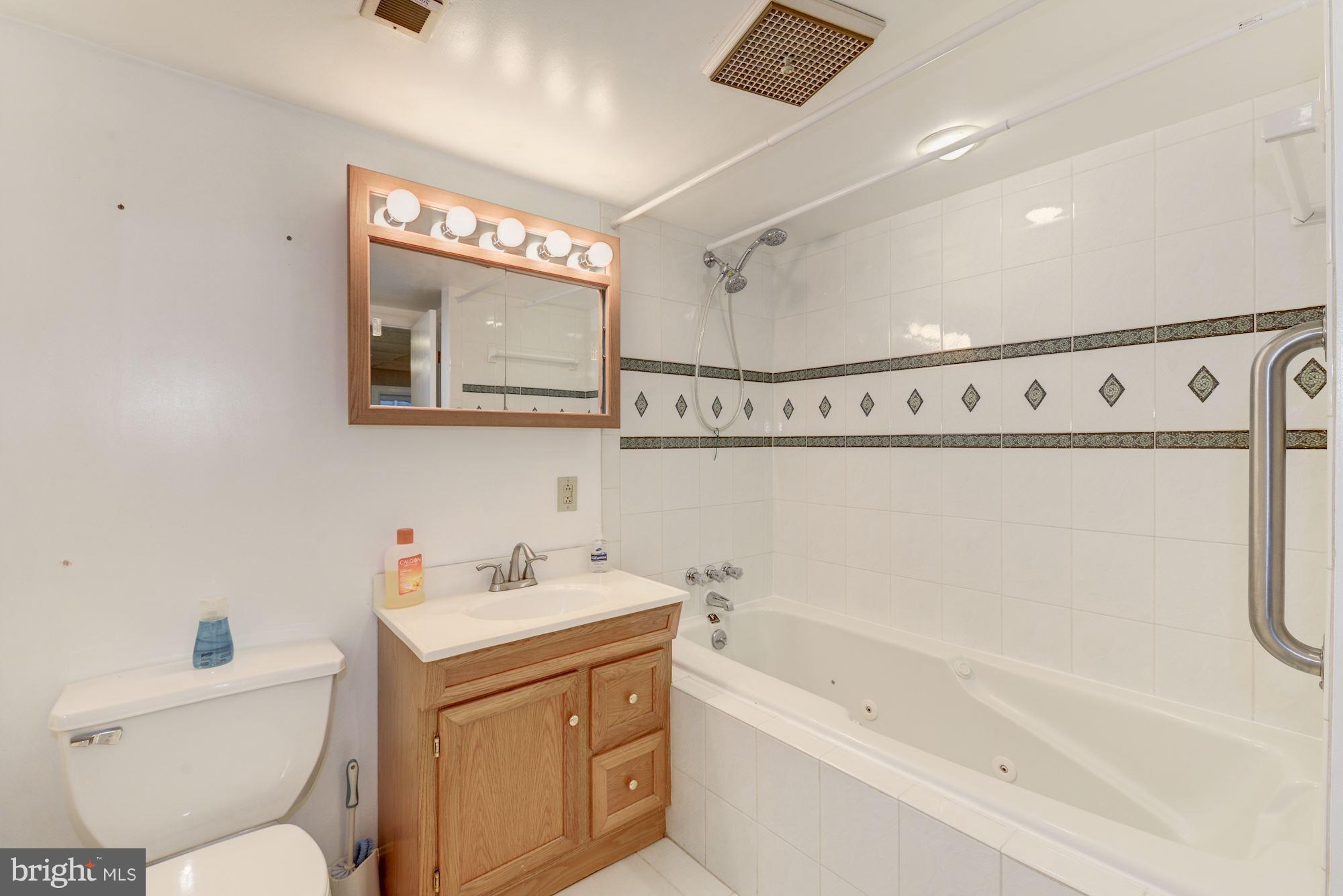 12510 Goodhill Road Silver Spring, MD 20906 - Photo 20 of 28 a bathroom with a sink mirror vanity and bathtub