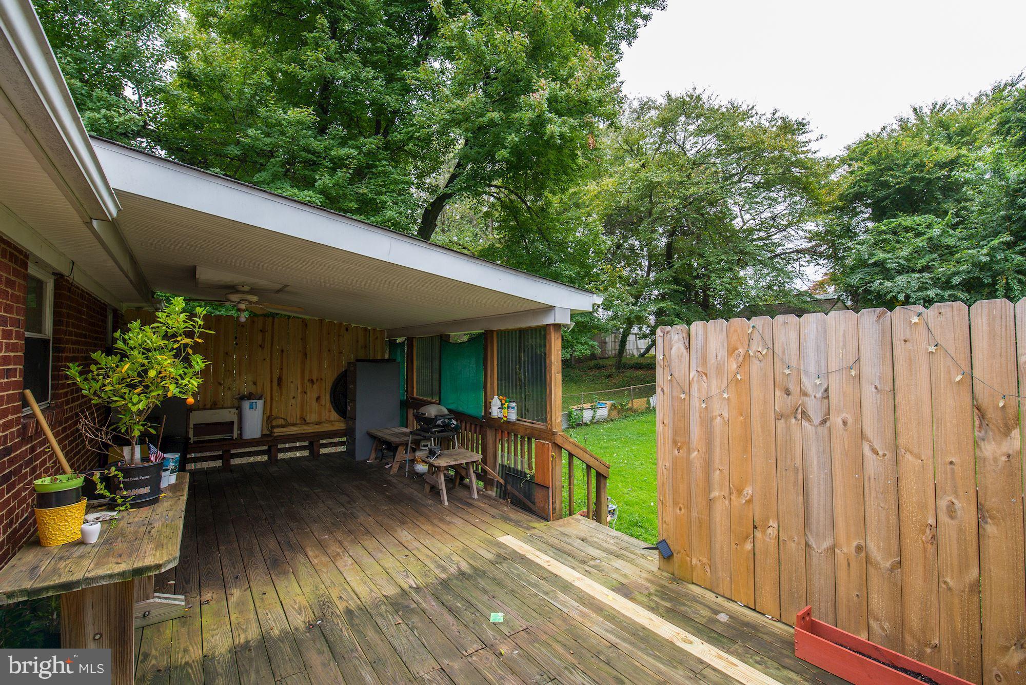 12510 Goodhill Road Silver Spring, MD 20906 - Photo 24 of 28 a view of a patio with table and chairs a barbeque with wooden floor and fence