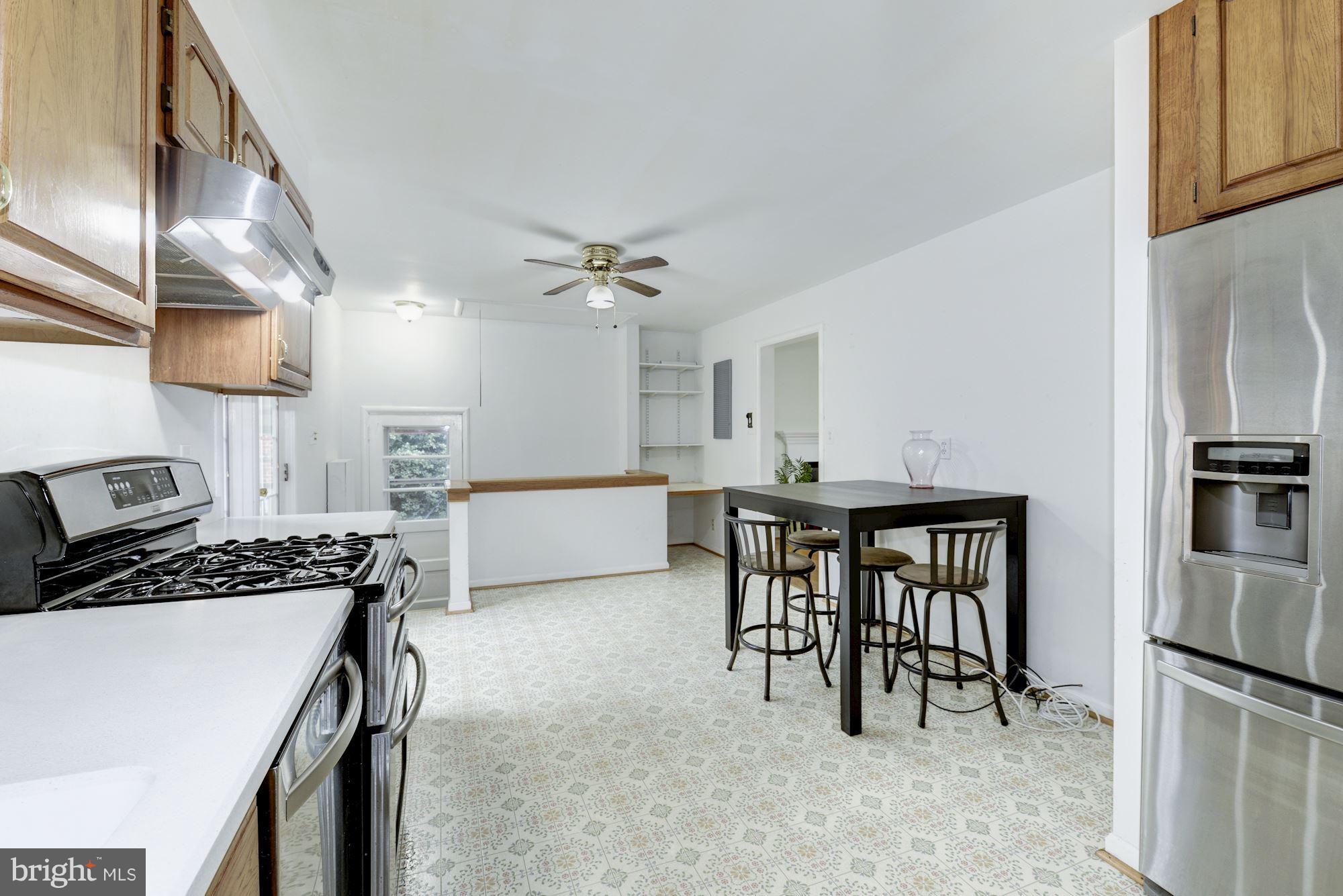 12510 Goodhill Road Silver Spring, MD 20906 - Photo 10 of 28 a kitchen with cabinets and chairs