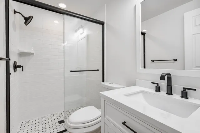 an empty room with wooden floor chandelier fan and windows