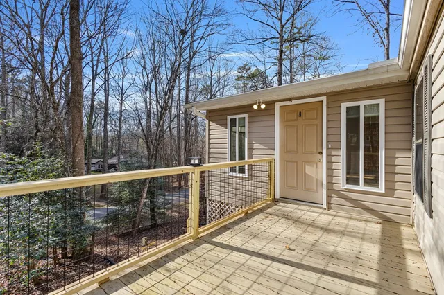 a view of a house with a large window and wooden fence