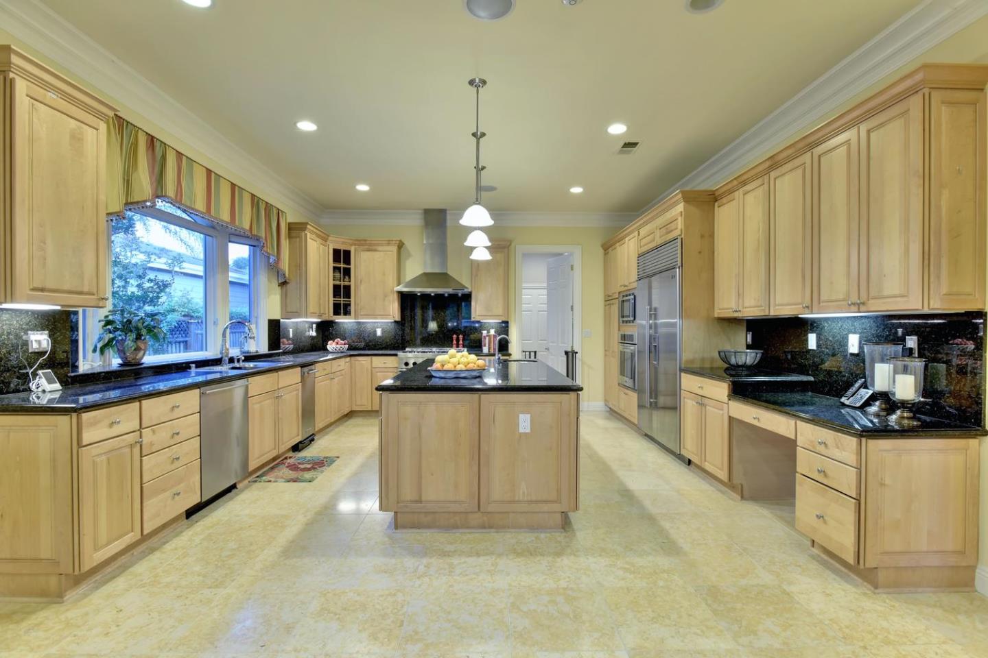 15867 Mina Way Saratoga, CA 95070 - Photo 17 of 43 a kitchen with stainless steel appliances kitchen island granite countertop a stove a sink a refrigerator a center island and cabinets