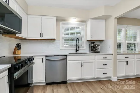 a kitchen with stainless steel appliances granite countertop a sink stove and cabinets