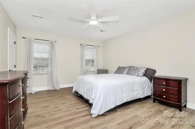 a spacious bedroom with a bed and a ceiling fan