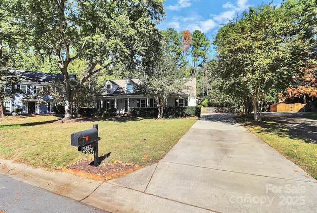 a view of swimming pool with outdoor seating and trees in the background