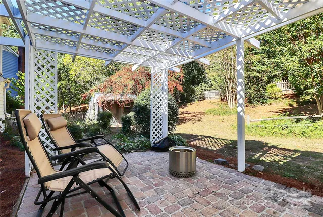 a view of a patio with table and chairs and wooden fence