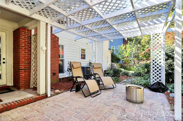a view of a patio with dining table and chairs and potted plants