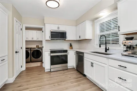 a kitchen with cabinets a sink and a stove top oven
