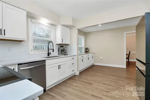 a kitchen with stainless steel appliances sink cabinets and wooden floor