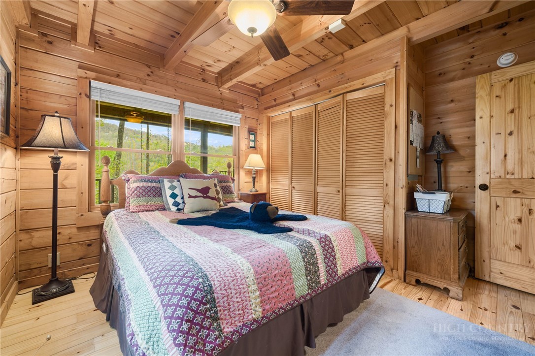 259 Greenbriar Road Beech Mountain, NC 28604 - Photo 16 of 41 a bedroom with a bed and wooden floor