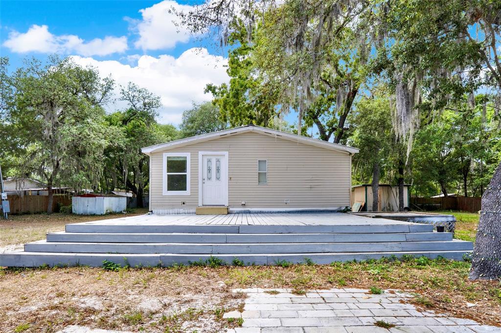 a view of house with backyard and seating area