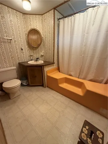 a bathroom with a sink a toilet and a shower curtain