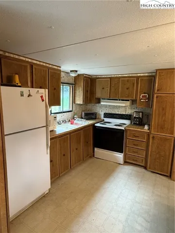 a kitchen with stainless steel appliances a refrigerator sink and cabinets