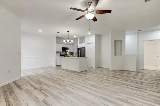 an empty room with a window and a ceiling fan