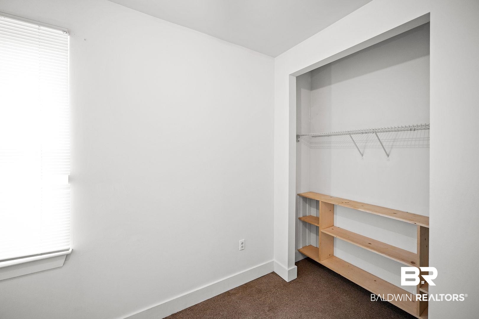635 East Azalea Avenue Foley, AL 36535 - Photo 9 of 18 Room featuring a window with blinds, baseboard molding, and carpeted flooring
