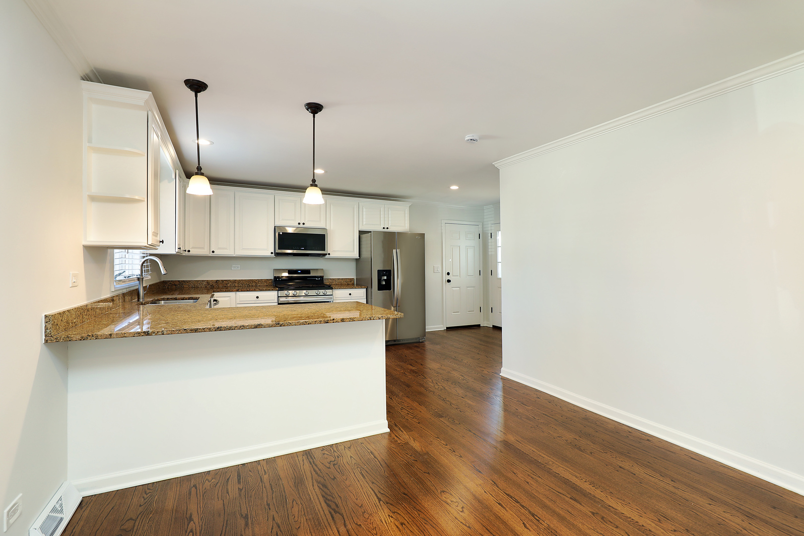 1913 Milton Avenue Northbrook, IL 60062 - Photo 16 of 24 a kitchen with stainless steel appliances granite countertop a sink a stove a refrigerator and island with wooden floor