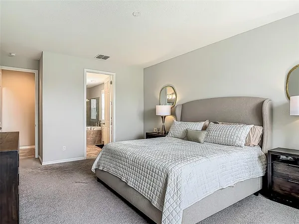 a bedroom with a bed and a lamp