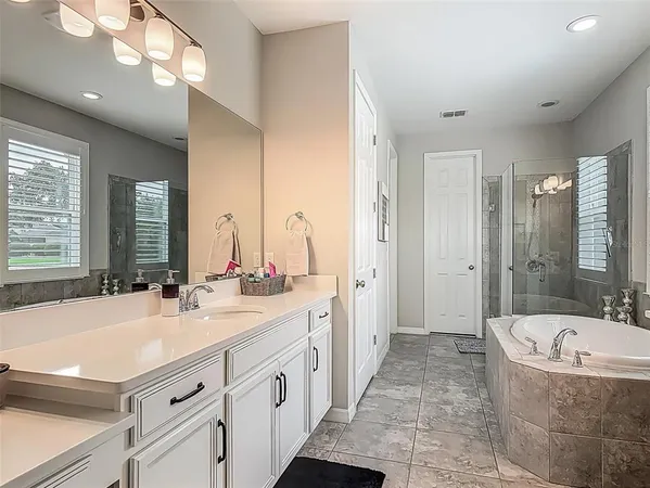 a bathroom with a tub sink and mirror