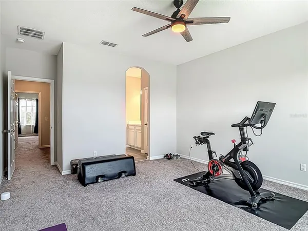 a room with gym equipment and view of a livingroom