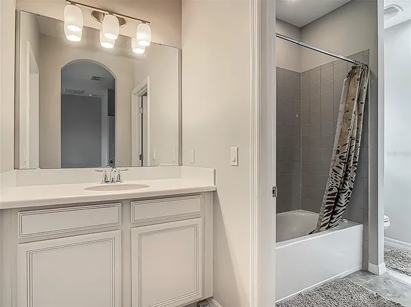 a bathroom with a tub a sink and mirrors