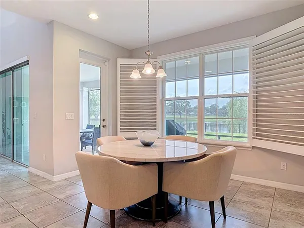 a dining room with furniture a chandelier and wooden floor