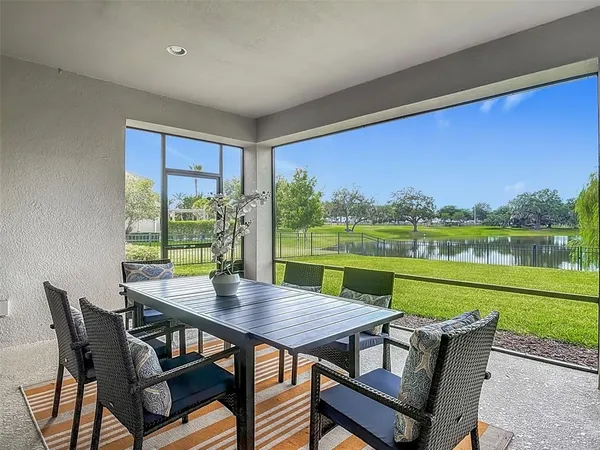 a view of a chairs and table in patio next to a yard
