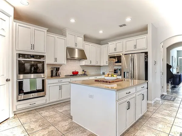 a kitchen with kitchen island granite countertop a stove oven and white cabinets