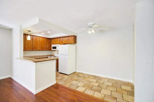 a kitchen with granite countertop a stove a sink and a refrigerator with wooden floor