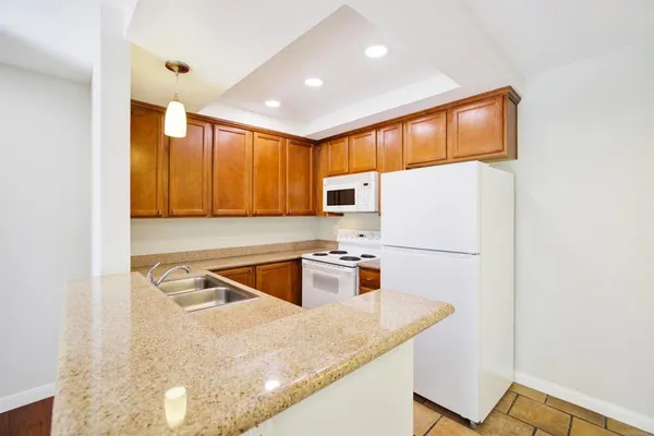 a kitchen with stainless steel appliances granite countertop a sink a stove and a refrigerator
